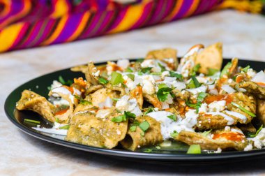Yeşil Chilaquiles, geleneksel Meksika vejetaryen kahvaltısı kızarmış tortilla ve yeşil sosla kaplanmış