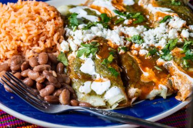 Enchiladas Verdes, ya da yeşil enchilada, tavukla doldurulmuş tortilla fasulye ve Meksika usulü pirinç ile servis edilir.
