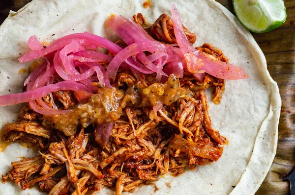 Cochinita Pibil 'in Meksika Tacoları, kızartılmış domuz eti, Yucatan usulü habanero sosu ve pembe turşulu soğan ile servis ediliyor.