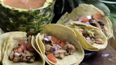 Erkek eli tacos al pastor üzerine kişniş yayıyor, Meksika yemeği. Baharatlı domuz eti ve domatesli ve soğanlı mısır tortillası ananaslı kırmızı salsa sosu.