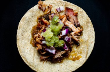 Kırmızı soğanlı Carnitas taco ve çiğ salsa verde. Meksika usulü yavaş pişmiş domuz eti tabağı.