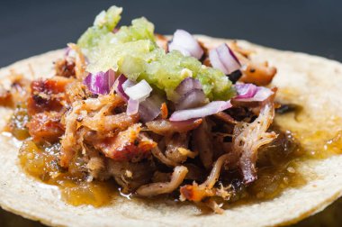 Kırmızı soğanlı Carnitas taco ve çiğ salsa verde. Meksika usulü yavaş pişmiş domuz eti tabağı.
