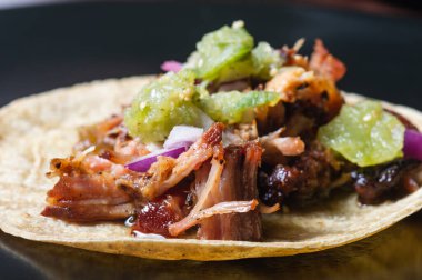 Kırmızı soğanlı Carnitas taco ve çiğ salsa verde. Meksika usulü yavaş pişmiş domuz eti tabağı.