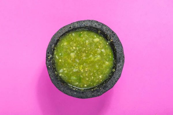 Çiğ salsa verde malzemeleri, Meksika yemeği. Domates, soğan, sarımsak, acı biber ve kişniş ezmesi. Pembe arka planda yeşil malzemeler.