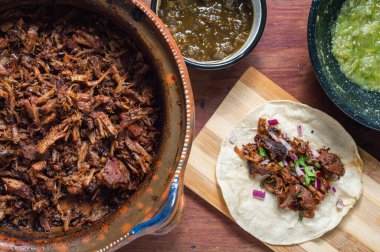 Carnitas tacos with red onion and raw green salsa clipart