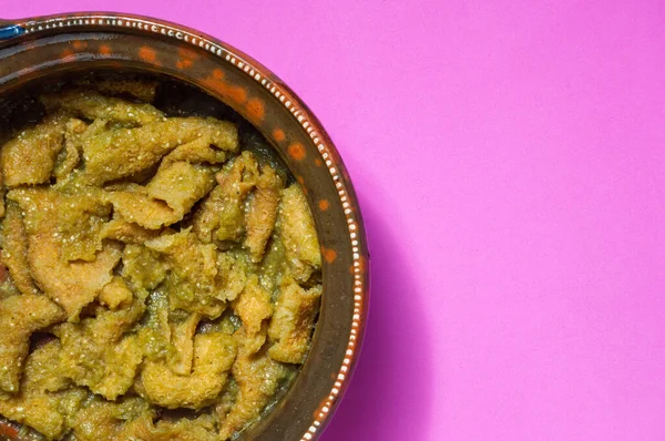 Yeşil salsa soslu domuz derisi, salsa verde soslu hindiba, Meksika yemeği. Meksika 'da geleneksel ve popüler bir kahvaltı. Kızarmış fasulye ve yumuşak mısır tortillası ile servis ediliyor.
