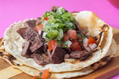 Meksika carne asada tacos, kelimenin tam anlamıyla ızgara et taco. Bunlar, salsa verde ve pico de gallo soslu yumuşak mısır totillalarında servis edilen ızgara sığır eti.