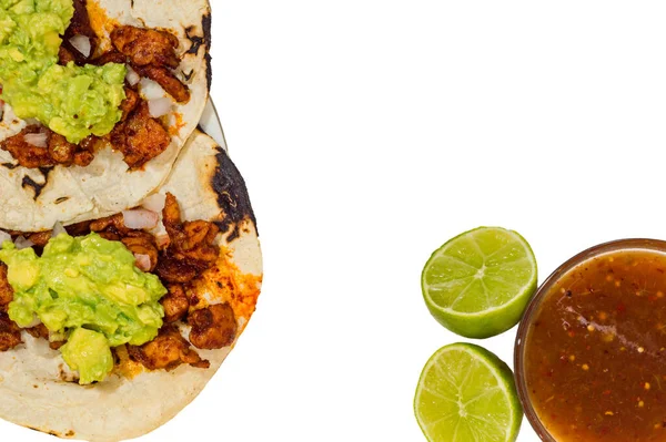 Tijuana tacos al pastor. Marinated pork on soft corn tortillas with guacamole and salsa isolated on white background. Mexican street food