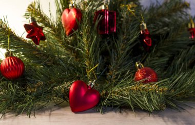 Yapay bir Noel ağacında kırmızı renkte Noel süslemeleri.