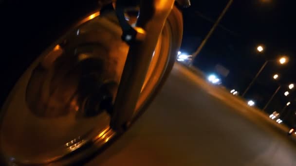 オートバイの街の道路で夜に乗っている 前輪オートバイのクローズアップ — ストック動画