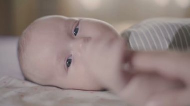 Annesi ve yeni doğmuş bebeği. Bebek bakar ve annenin elini tutar. Yavaş Hareket