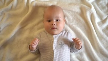 Sevimli bebek gülümsüyor ve kameraya bakıyor. Bir bebeğin portresi. Yakından, 4k.