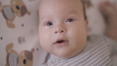 Güzel bebek kameraya bakıyor ve gülümsüyor
