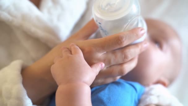Baby Håller Mödrar Hand Och Dricker Mjölk Från Flaska — Stockvideo