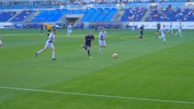 Futbolcular futbol sahasında top için savaşır.