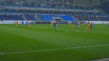 Futbol maçı, bir oyuncu topu penaltı sahasına atıyor..