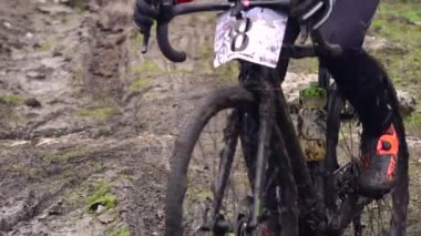 Toprak yolda bisiklet yarışı. Bir spor bisikleti tekerinin off-road ve pisliğe yakın çekimi. Sporcu pedallar yarışmalarda spor bisikleti kullanır. Slow Motion, 250 fps