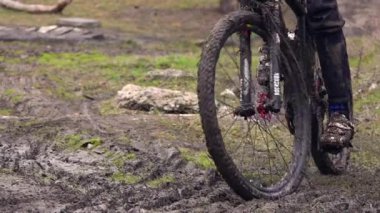 Toprak yolda bisiklet yarışı. Bir spor bisikleti tekerinin off-road ve pisliğe yakın çekimi. Sporcu pedallar yarışmalarda spor bisikleti kullanır. Slow Motion, 250 fps