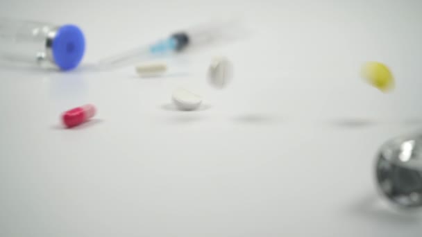 Barevné Pilulky Padají Zpomaleně Prášky Lahvičky Léky Stříkačka Bílém Pozadí — Stock video