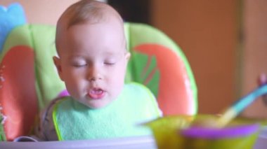 4 bin. Bebek Koltuğa Oturur ve Yulaf lapası yer. Anne, çocuğu kaşıkla lapayla besliyor.. 