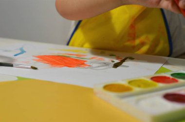 Beyaz bir masada bir çocuk oturuyor.