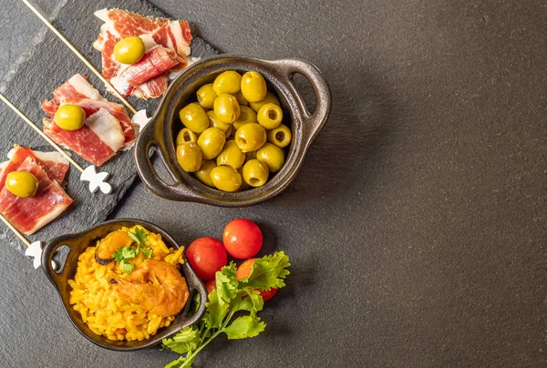 Spanish tapas, Iberian ham, Valencian paella and olives — Stock Photo, Image