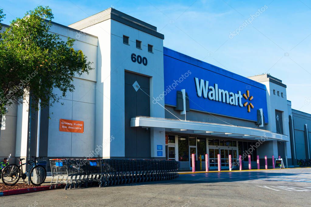 Walmart store facade. Row of shopping carts are ready for customers. Anti ram raiding bollards secure Wal-mart entrance from accident or theft - Mountain View, California, USA - November, 2019