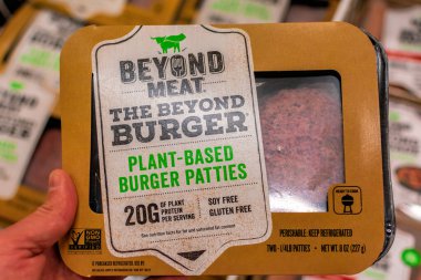 Vejetaryen bir alışverişçi elinde bir paket Beyond Meat Burger paketi tutuyor.