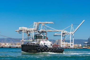 Oakland Uluslararası Konteyner Terminalinde römorkör destek konteynır gemisi.