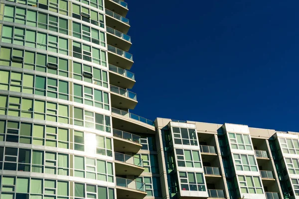Außenansicht eines typischen neuen Mehrfamilien- und Hochhaus-Wohnhauses unter blauem Himmel. — Stockfoto