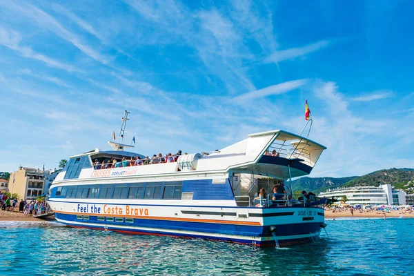 Touristen und Besucher besteigen das Kreuzfahrtschiff dofi jet iii für einen Ausflug entlang der Costa Brava. Sandstrand mit schönem blauen Himmel — Stockfoto