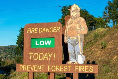 Smokey Bear 'ın alçak ateş tehlikesi işareti, Wildfire Prevention kampanyasının bir parçası.