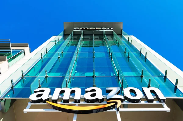 Amazon logo met zijn kenmerkende oranje glimlach op de glazen gevel van de bedrijfscampus in Silicon Valley — Stockfoto