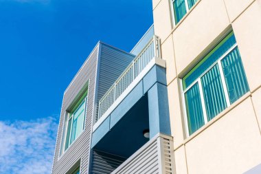 Mavi gökyüzünün altında balkonu olan tipik yeni orta-aile yerleşim yerlerinin dış görünüşü