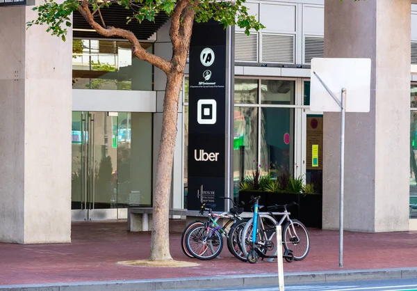 Quadrat und Uber-Logo in der Nähe des Eingangs zum Hauptquartier von Softwareunternehmen in der Marktstraße — Stockfoto