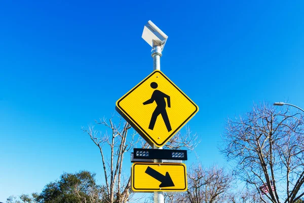 Pedestrian crossing sign with solar powered flashing lights. Crosswalk beacon provides advance notice of pedestrian activity for drivers
