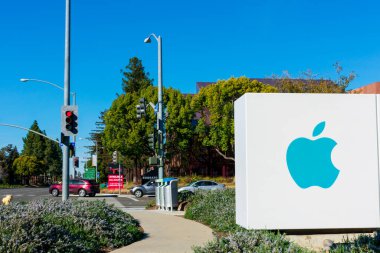 Güneşli bir günde Amerika 'nın çok uluslu teknoloji şirketi merkezi olan Cupertino, California, ABD' nin sokak girişinin reklamında Apple logosu - 2020