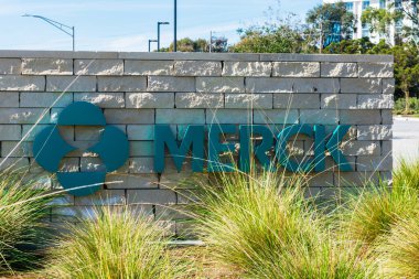 Merck logosu ve imzası Silikon Vadisi 'ndeki Merck Araştırma Laboratuvarları' ndaki yeşil peyzaj arkasına gizlenmiş pn levhası - Güney San Francisco, CA, ABD - 2020