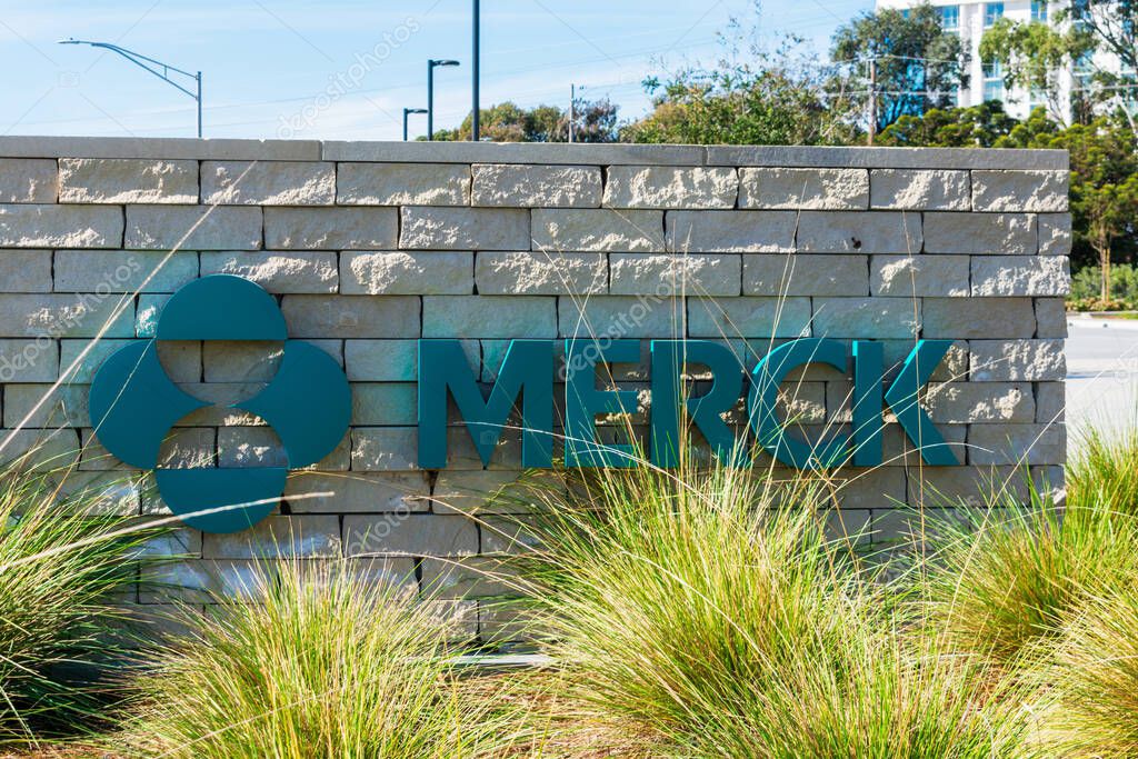 Merck logo and sign pn signpost hidden behind green landscaping at Merck Research Laboratories in Silicon Valley - South San Francisco, CA, USA - 2020
