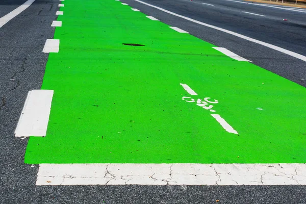 Close up. Green colored bike lane surfacing communicates to road users that a portion of the roadway has been set aside for preferential or dedicated use by bicyclists.