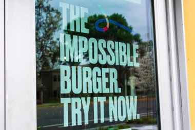 İmkânsız Burger posteri fast food restoranında etsiz bitki bazlı yemek reklamları yapıyor. İmkânsız Gıda şirketi San Francisco, California, ABD 'den gelen vegan burger.