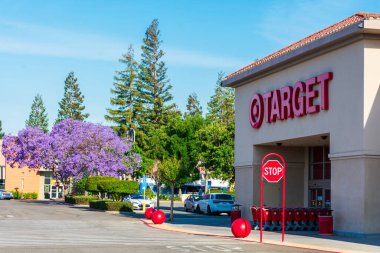 Mağaza girişinde mağaza müşterileri için alışveriş kartları hazır olsun. Güzel Jacaranda ağacı açık hava otoparkında - Cupertino, California, ABD - 2019