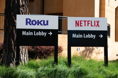 Roku ve Netflix, ziyaretçileri Silikon Vadisi 'nin ünlü medya şirketleri Los Gatos, Kaliforniya, ABD' nin ana lobisine yönlendiren bilgilendirme tabelaları.
