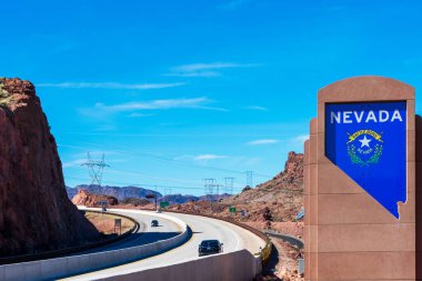 Otoyoldaki Nevada Anıtı tabelasına hoş geldiniz. Durgun eyalet silueti, kalın beyaz harflerle ve Nevada arması - Boulder City, Nevada, ABD - 2020
