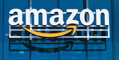 Amazon logosu, modern şirket kampüsünün cam cephesine yansıyan turuncu gülüşüyle Palo Alto, Kaliforniya, ABD - 2019