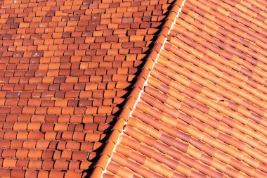 Tepe kiremitli klasik kırmızı kil çatı manzarası yükseltildi. Kırık bir fayans görünüyor..