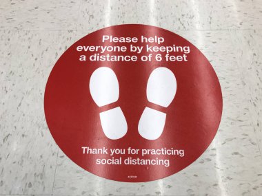 Social Distancing sign on the floor of Target supermarket requesting customers to practice distance of at least 6 feet in order to prevent spread coronavirus - San Jose, California, USA - March, 2020 clipart