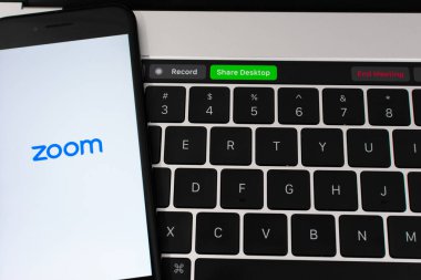 Bir akıllı telefonda Zoom video konferans mobil uygulaması açıldı. MacBook Pro Touch Bar, Zoom uygulaması toplantılarını gösteriyor - San Jose, California, ABD - 2020