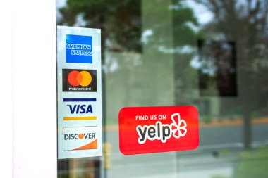 MasterCard, VISA, American Express restoran kapısında reklam edilmiş ödeme seçenekleri. Kırmızı etiketli çıkartma Yelp 'te kalabalıktan kaynaklanan eleştiri servisi San Francisco, Kaliforniya, ABD - 2020