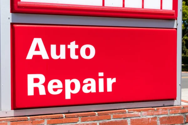 Auto repair sign, white letters and red background, advertises auto repair shop services